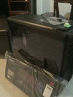 Mid-tower computer case next to sealed Havit gaming combo packaging