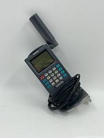 Garmin GPS 50 handheld GPS device with extended antenna, screen, and keypad, cable wrapped around its base.