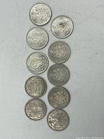 Ten Canadian 50 cent silver coins arranged in two vertical columns, front and reverse sides showing coat of arms and denomination with years.