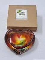 Robert Held heart-shaped art glass bowl with a colorful swirl pattern and original Side Street Studio box on a white background.