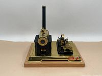 Front view of the complete engine assembly on brass plate and wooden base