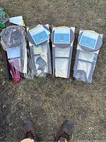 Four new wooden bar stools parts laid on grass, individually wrapped in plastic and cardboard packaging