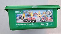 Green plastic container with colorful label illustrating the Brio wooden railway set including trains and cranes, marked age 3+, item number 33097.