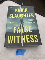 Book cover showing 'False Witness' title and author Karin Slaughter with design of torn line down center.