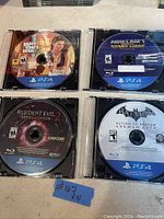 Photo of 4 PS4 game discs in jewel cases: Grand Theft Auto V, Minecraft Story Mode, Resident Evil Revelations 2, Batman Return to Arkham
