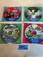 Photo of four PS4 game discs and cases laid out on a surface. Visible games: Red Dead Redemption 2, Dragon Age: Inquisition, Gigantosaurus The Game, Yooka-Laylee.