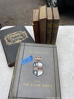 Six antique books arranged standing and laid flat showing titles and condition.