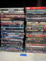 Photo showing a stack of 41 DVD movie cases with titles visible including March of the Penguins, Harry Potter series, Pirates of the Caribbean series, and others.