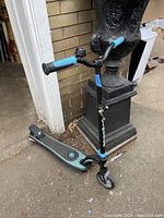 Side view of the black and blue Globber battery powered scooter showing handlebar, deck and front wheel