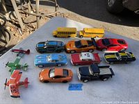 View of all 11 toy vehicles including 9 cars and 2 airplanes arranged on table, showing variety of models and colors