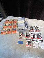 Wide view showing Fire type Pokémon cards, large pile of assorted cards in container, and several sports cards including Tim Hortons hockey and a baseball card