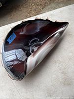 Top and side view of an art glass dish with dark brown and white layered colors and pointed edges along the rim.