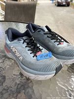 Front and top view of the Saucony men's running shoes showing the overall design, brand name, and size label on blue tape.