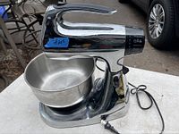 Side view of Sunbeam Mixmaster stand mixer showing chrome body and attached stainless steel bowl.