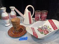 Full lot of Ukrainian ceramic and decorative items including vases, watering can, glass tumblers, bowl, and wooden cup set.