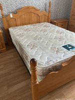 Full view of double bed with headboard, footboard, mattress and box spring in bedroom setting