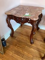 Front and full view of the end table showing marble top and carved wooden legs and apron.