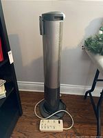 Full view of the Seville Classics tower fan and included white power bar positioned on the floor.