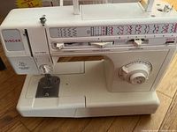 Full view of Singer sewing machine with stitch selection panel, dial controls, and free-arm base.
