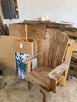 Pile of assorted wood remnants leaning against wall with plywood and solid planks visible
