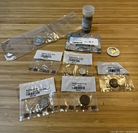 Overview of seven coins and tube arranged on tabletop