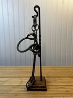 Photo showing the full metal hanging puzzle mounted on twisted metal rod with wooden base.