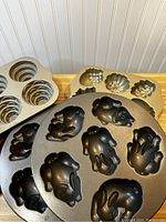 Photo showing 3 metal baking pans with turkey-shaped molds and various flower or leaf shaped molds.