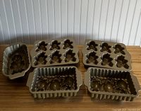Five Nordic Ware metal baking pans on wooden surface showing detailed pumpkin and gingerbread man molds.