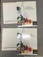 Top-down photo showing two identical 1981 commemorative mint postal stamp sets in cream-colored presentation folders featuring space shuttle and floral illustrations.
