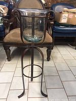 Front view of the metal stand holding the large clear glass globe candle holder.