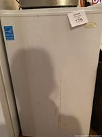 Closed view of the white Salton compact freezer with noticeable marks and energy star label.