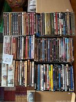 Photo showing a large number of DVD cases arranged in rows, mostly movies with some TV box sets visible.