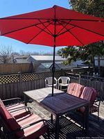 Overview of table, umbrella, two chairs and bench on deck
