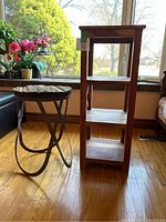 Photo showing both the tall wooden side table with three shelves and the smaller iron base side table with weathered wood plank top.