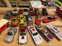 Overview of 16 die cast cars and vehicles in various colors including race cars, vintage and sports cars, and specialty vehicles.