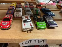 Front view of 15 die cast model cars arranged in two rows showing various racing liveries including 'Hills Bros,' 'Melling Compton,' and 'Bud' branding