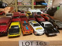 Photo showing front row of various die cast car models in multiple colors including racing cars with numbered decals.