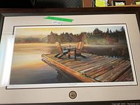 Full view of the framed art with dock, chairs, water, and trees under morning light.