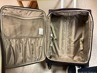 Open Samsonite luggage showing interior compartments with elastic straps and mesh pockets.