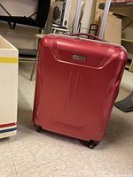 Front view of red hard shell Samsonite suitcase showing overall condition and design