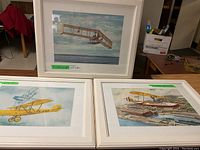 All three framed aircraft prints displayed on floor, showing overall lot condition and style.