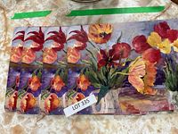 Six rectangular floral placemats with vibrant colorful tulip and flower design spread out overlapping slightly.