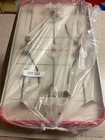 Full view of vintage tabletop hockey game in plastic wrap showing playing surface, goals, and player rods.