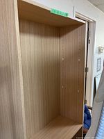 Front view of empty wooden shelving unit showing adjustable shelf holes.