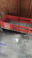 Full view of the red wooden wagon marked Radio Town and Country inside a shed showing overall condition and size.