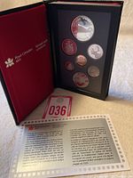 Full view of the 1986 Canadian Double Dollar Proof Set in black display case with red cover from Royal Canadian Mint, including all coins and certificate of authenticity, with card numbered 036