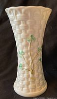 Front view of the Belleek basketweave vase showing the cream color and green shamrocks on the textured body.