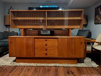 Front view of the complete buffet and hutch showing wood grain finish, drawers and glass doors