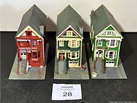Front view of three HO scale train model houses on display boards showing stairs, porches, and front details.