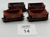 Four rust/reddish-brown HO scale ore cars, two loaded with coal, two empty. Detailed Union Pacific railroad markings visible.